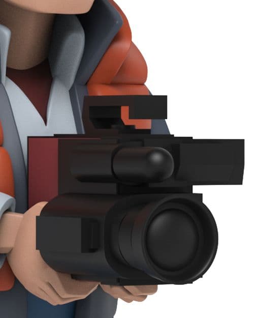 Marty McFly holding a black video camera at chest level, across his red vest.