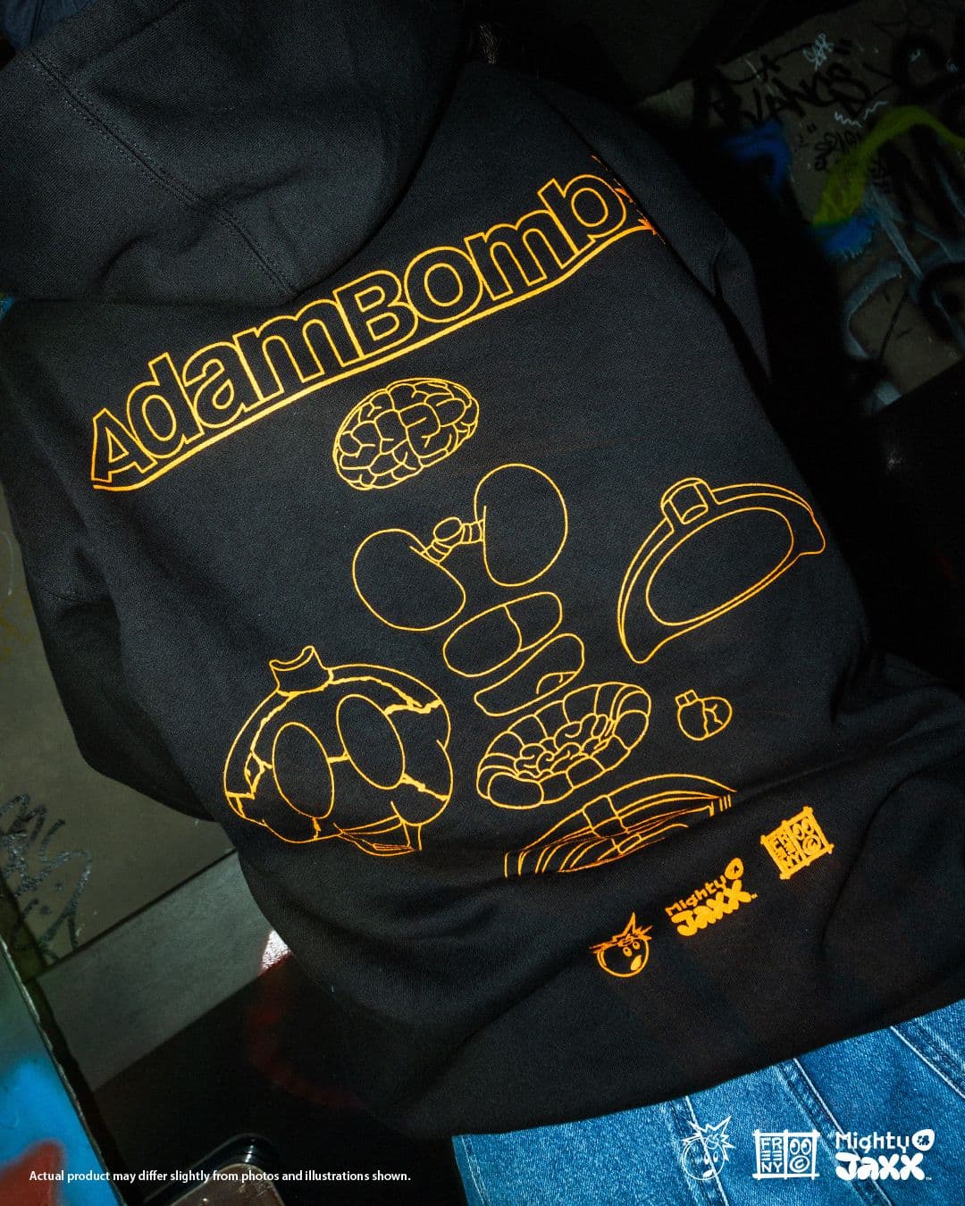 Back view of black Adam Bomb hoodie with orange line-art schematics of Adam Bomb parts and bold logo across the shoulders